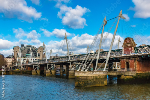 Great view of the Hungerford Bridge over London's river Thames, flanked by cable-stayed, pedestrian bridges named the Golden Jubilee Bridges. Its official name is Charing Cross Bridge. photo