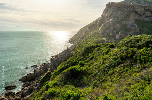 Majestic golden light during golden hour with A rocky coastline of the peninsuala at Robberg nature reserve along the Garden route, Plettenberg Bay, Western Cape province, South Africa, Africa
 photo