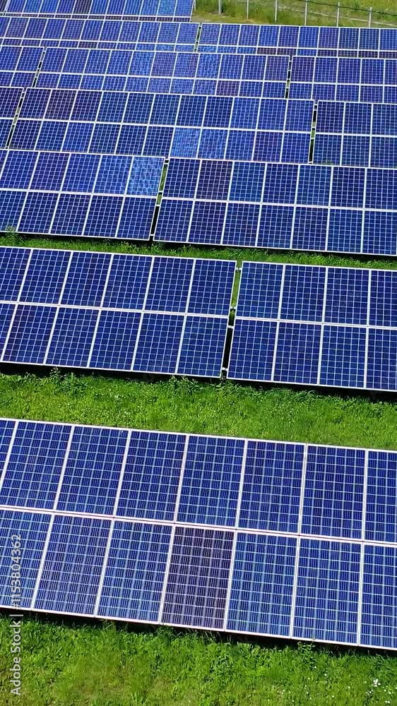 Photovoltaic panels on green field. Blue sunny batteries get clean energy from the sun. Innovative solar power station. Renewable energy. Vertical video Photovoltaic panels on green field. Blue sunny batteries get clean energy from the sun. Innovative solar power station. Renewable energy. Vertical video