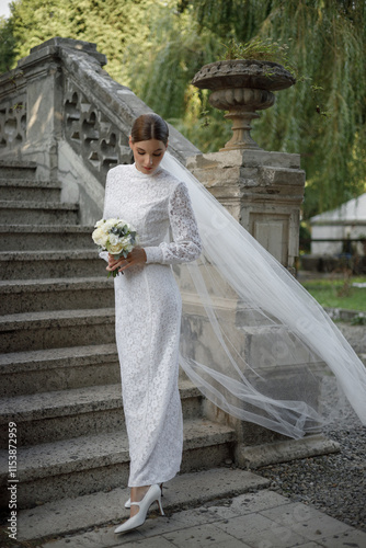 An Elegant Bride Adorned in a Stunning White Lace Dress on Beautiful Garden Stairs