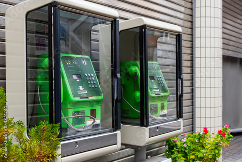 Public phone booth in Japan, green color pay phone with braille for the blind. photo