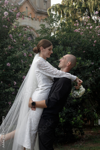 A Romantic Embrace Between a Wedding Couple Surrounded by a Beautiful and Lush Garden