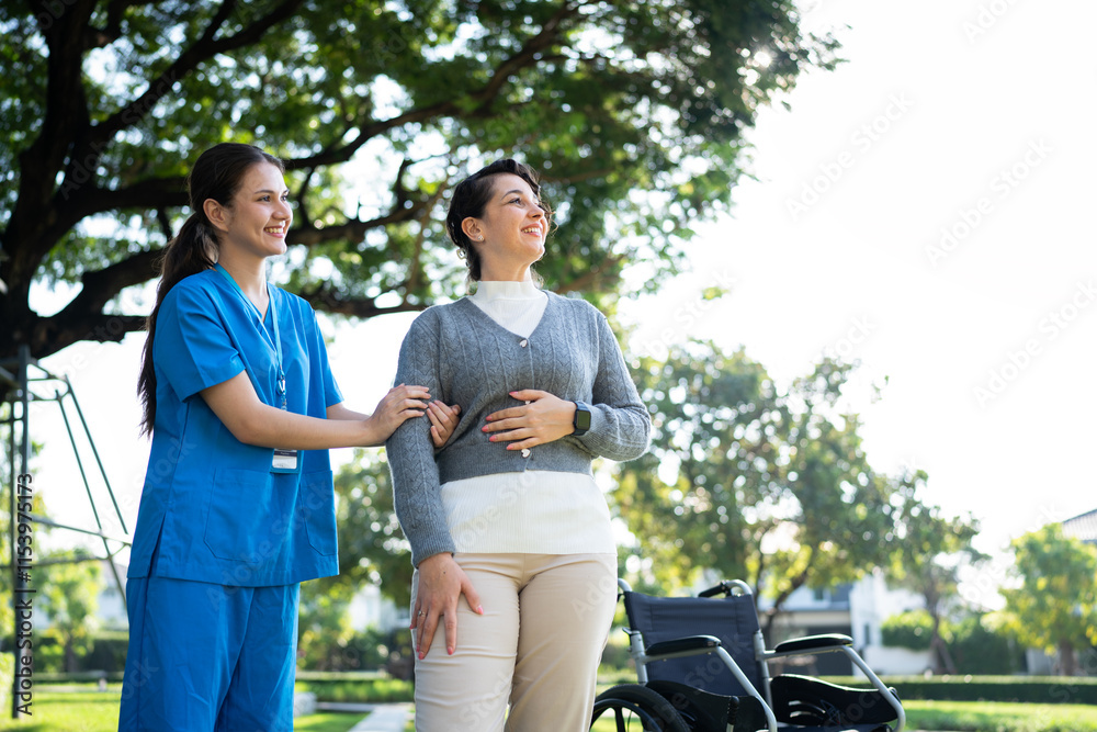 A nurse in blue scrubs helping a woman stand near a wheelchair in a sunny park, offering care and encouragement. A nurse in blue scrubs helping a woman stand near a wheelchair in a sunny park, offering care and encouragement.