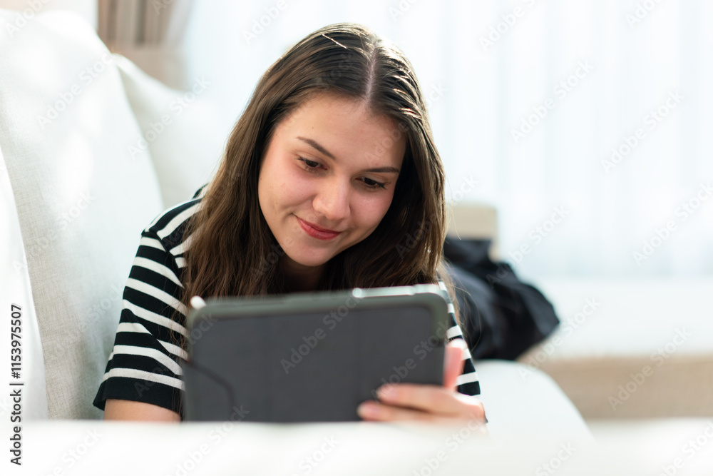 Smiling woman working on digital devices at home Smiling woman working on digital devices at home