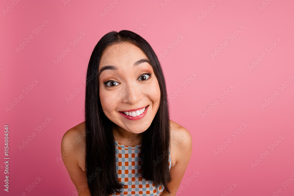 Joyful young Asian woman with long brunette hair, smiling cheerfully against a vibrant pink background Joyful young Asian woman with long brunette hair, smiling cheerfully against a vibrant pink background
