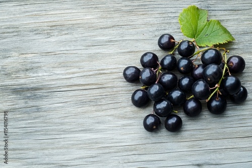 Dark, Juicy Black Currants on Rustic Wooden Tabletop: A Vibrant Display of Nature's Bounty photo