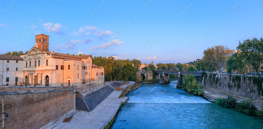 Rome cityscape: glimpse of Tiber Island on the Tiber River at sunset.