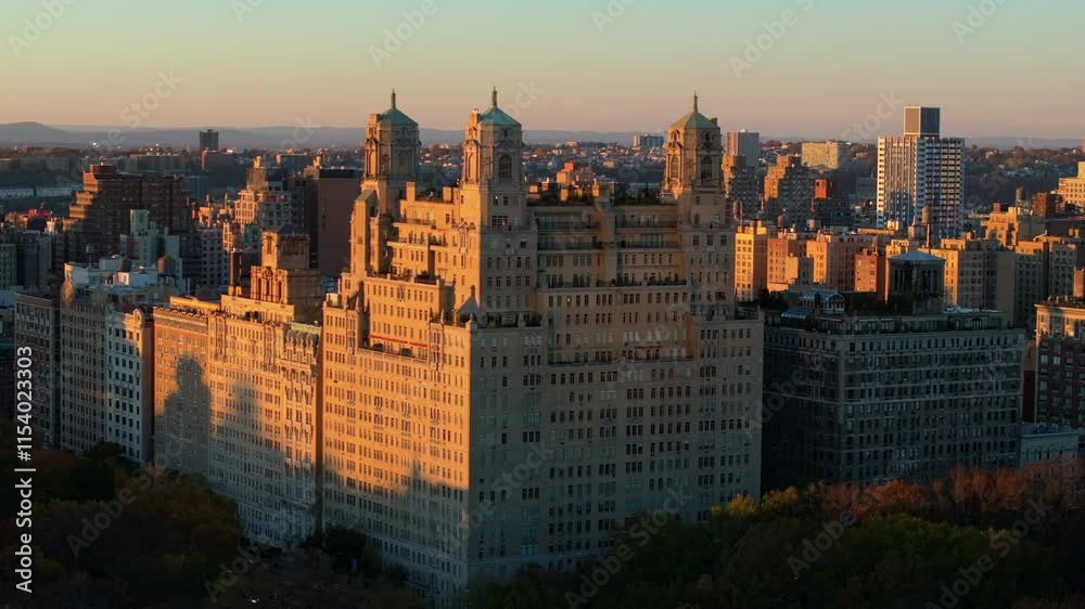 Warm sunlight bathes the elegant facade of the Beresford cooperative apartment building in New York City's Upper West Side neighborhood as the sun sets over Central Park Warm sunlight bathes the elegant facade of the Beresford cooperative apartment building in New York City's Upper West Side neighborhood as the sun sets over Central Park