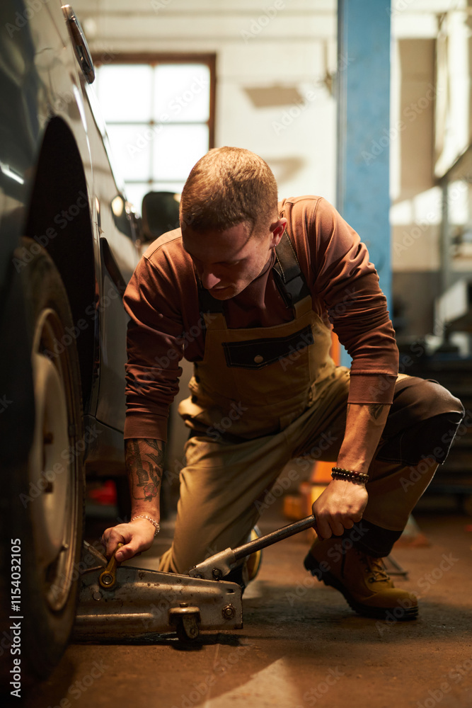 Worker using equipment to change wheels of the car in service Worker using equipment to change wheels of the car in service