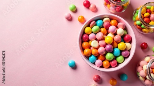 A Colorful Bowl of Sweet Treats and Glass Jars Overflowing with Assorted Candy on a Pink Background