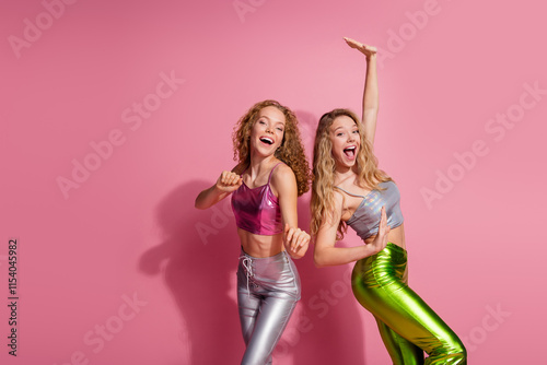 Stylish young women in vibrant outfits, smiling joyfully against a pink backdrop, celebrating friendship and fashion in a fun disco party theme photo