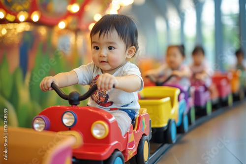 Asian toddler enjoying indoor train ride with friends