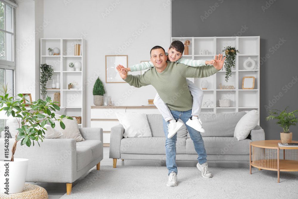 Fototapeta premium Cute little boy with his father having fun at home