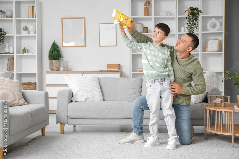 Fototapeta premium Cute little boy and his father playing with plane at home