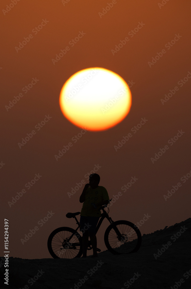 Fototapeta premium Silhouette of a biker during sunset at Bahrain