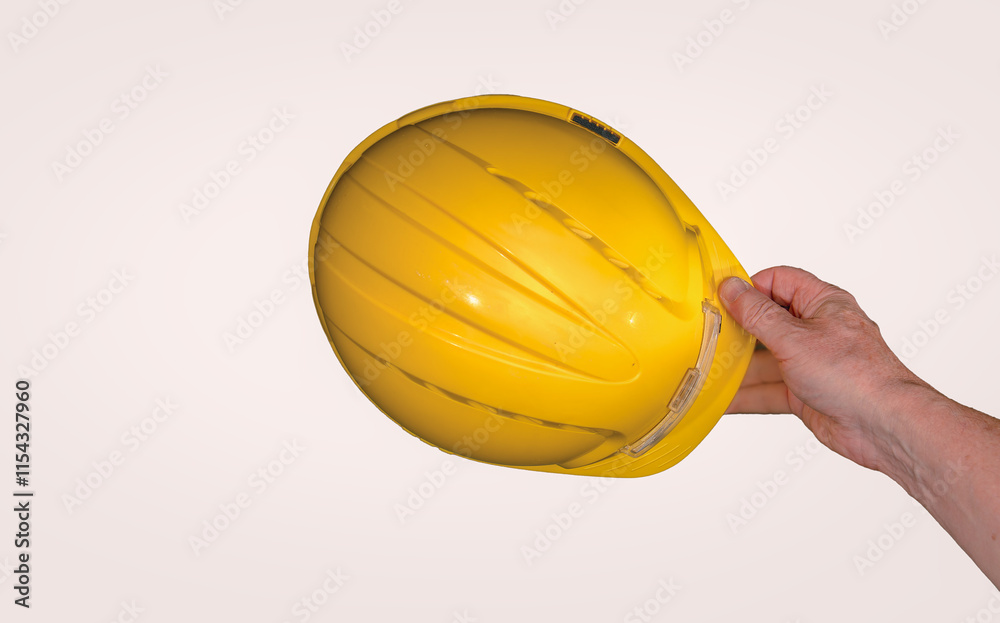 Construction worker holding a yellow safety helmet