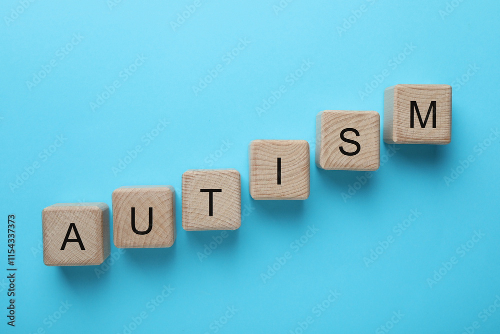 Word Autism made of wooden cubes on light blue background, top view Word Autism made of wooden cubes on light blue background, top view