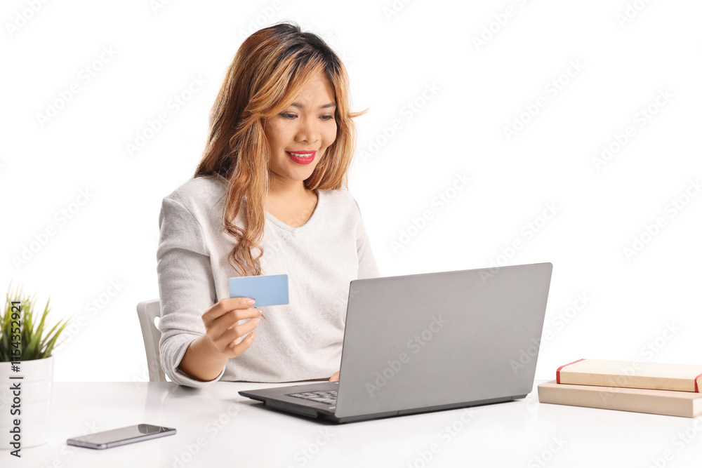 Asian woman shopping online with a laptop computer and credit card Asian woman shopping online with a laptop computer and credit card