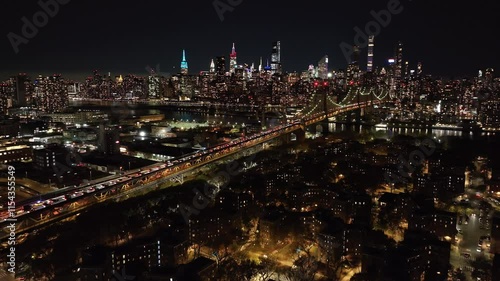 Wallpaper Mural Aerial view capturing lively movement of vehicles on Queensboro Bridge, directing towards glowing skyline of Manhattan, New York City at night Torontodigital.ca