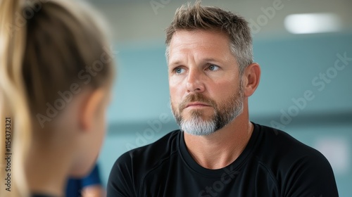 A thoughtful man with light hair and beard is attentively listening, engaged in a conversation, a sense of focus and understanding shown through his expression. photo