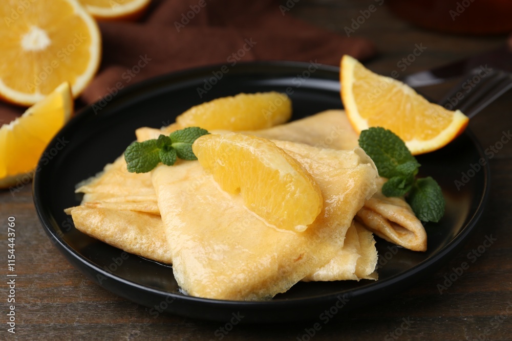 Delicious Crepes Suzette served on wooden table, closeup Delicious Crepes Suzette served on wooden table, closeup