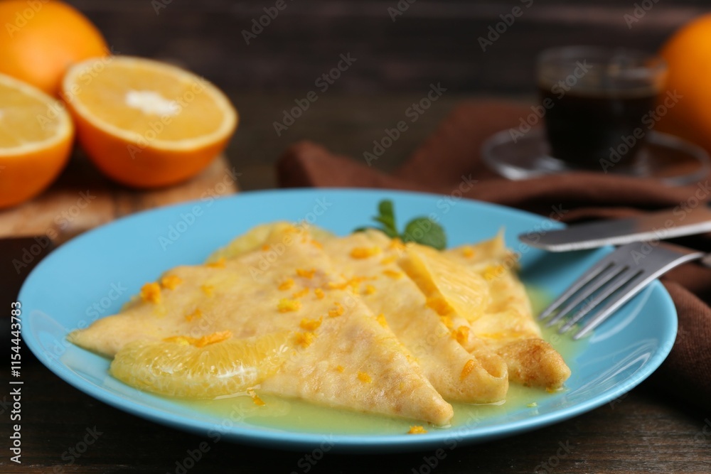 Plate with tasty crepes Suzette on wooden table, closeup Plate with tasty crepes Suzette on wooden table, closeup