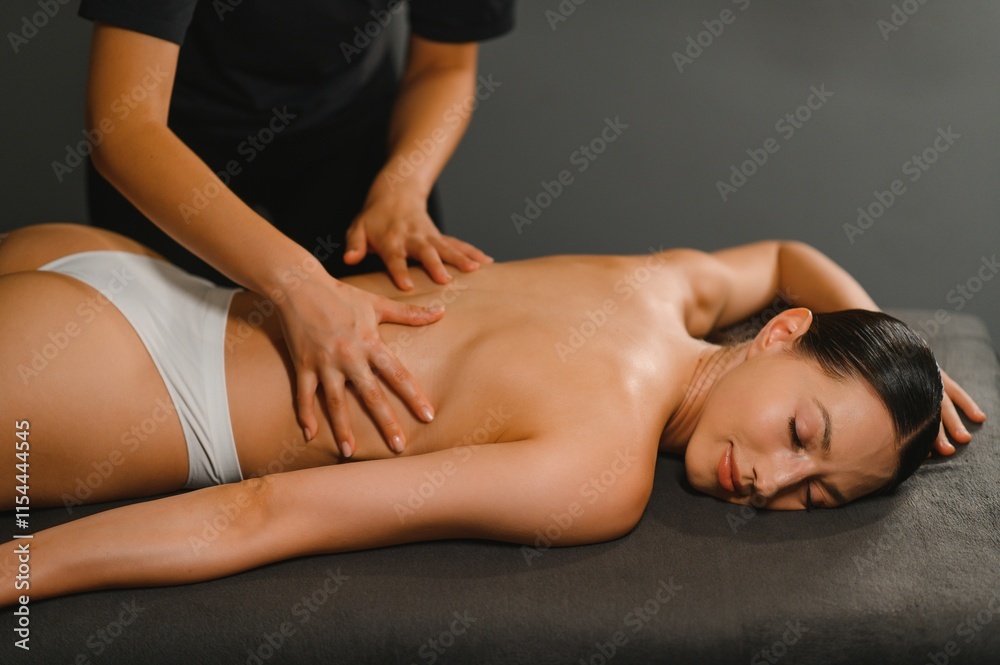 Obraz premium Masseur doing massage on woman back in the spa salon
