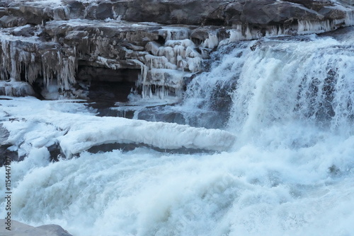 In winter, the Yellow River in China freezes over, thundering through the gorge as chunks of ice hang and dangle dramatically from its banks. photo