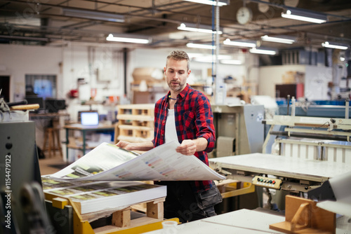 Foto Male factory worker working in industrial printing office