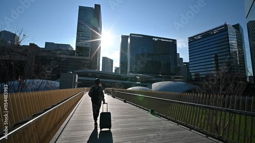 キャリーケースを持った女性旅行者の後ろ姿