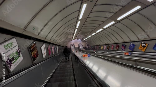 People walking down the escalator at an underground station in London