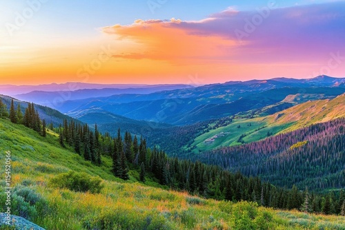 A vibrant sunset over rolling green hills and mountains.