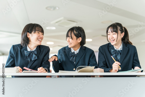 学校の教室で授業中に楽しく話す制服姿の小学生・中学生・高校生・女子高生（友達）
 photo