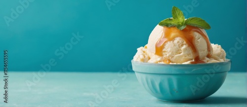 Blue bowl with vanilla ice cream, caramel sauce, and mint on turquoise background. Warm and inviting atmosphere.