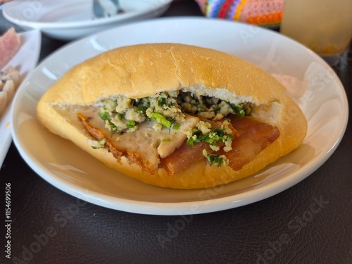 Local baked bread or bun filling with minced pork, sausage and pork serving on the plate. Famous easy breakfast menu in Asia.