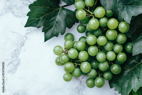 A bunch of fresh green Shine Muscat grapes with glossy skin, placed on a white background with detailed leaves. photo