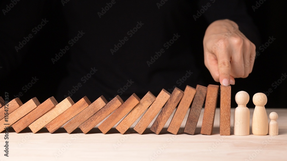 Naklejka premium Risk Management Strategies Hand Stopping Falling Dominos in Business Crisis Decision Making Conceptualized in a Controlled Environment