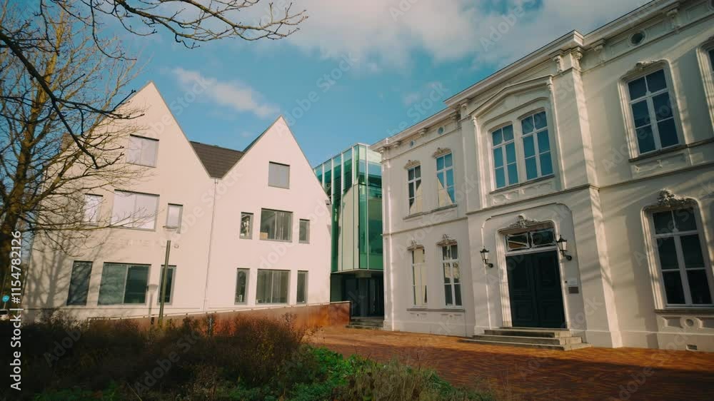 Blend of modern and classic architecture with clean lines and large windows adjacent to historic facades in Geldrop, Noord-Brabant. The fusion highlights urban development amid cultural heritage Blend of modern and classic architecture with clean lines and large windows adjacent to historic facades in Geldrop, Noord-Brabant. The fusion highlights urban development amid cultural heritage