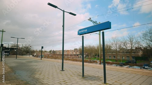 Peaceful morning scene at Geldrop train station, with clean platforms, light poles, and natural surroundings. Netherlands photo