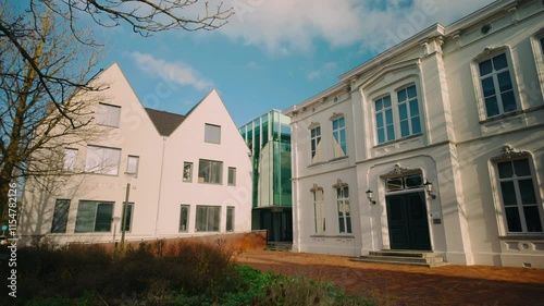Blend of modern and classic architecture with clean lines and large windows adjacent to historic facades in Geldrop, Noord-Brabant. The fusion highlights urban development amid cultural heritage photo