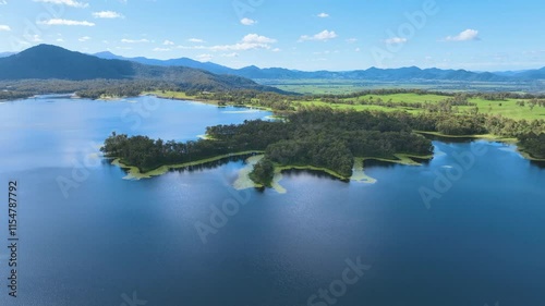 Relaxed flight above the azure waters of MacKay's Teemburra Dam and flooded valley remnants covered in lush forests Pinnacle Queensland Australia photo