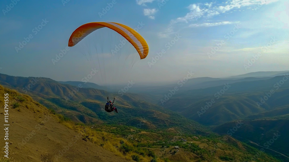 The paraglider glides gracefully from the top of the vibrant hill, as the sun dips below the horizon The paraglider glides gracefully from the top of the vibrant hill, as the sun dips below the horizon