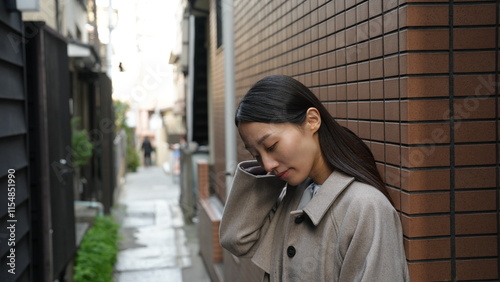 路地で待ち合わせをする女性