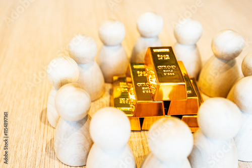 Gold is placed on a table with a model of a group of people who want gold around it. The concept of a safe asset that people are interested in and valuing a lot is gold. photo