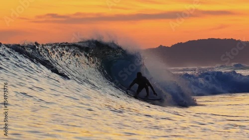Male surfer on a wave at sunset time at Indian Ocean