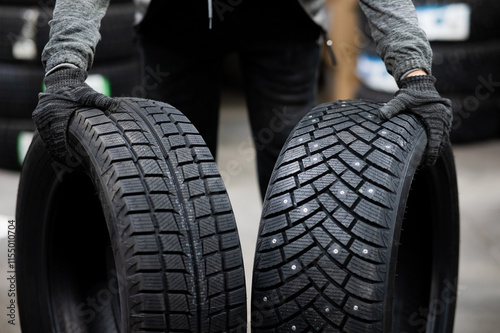 Mechanic keeps new summer and winter car tires in the garage. Comparison of wheels for different seasons. 