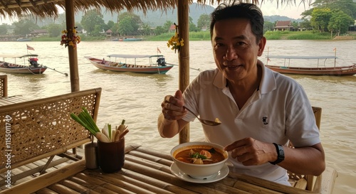Man enjoys delicious Tom Yum soup by the river