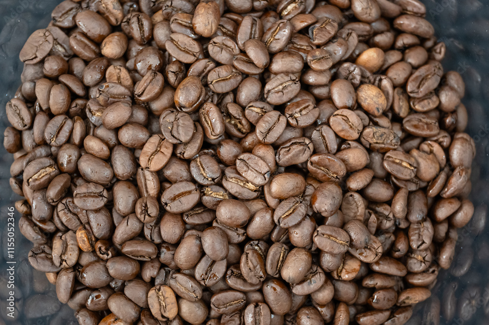 Fototapeta premium Close-up of roasted arabica coffee beans.Heap of coffee beans stacked prepare making menu in the cafe by machine ready to be brewed into a delicious cup.Textured background.