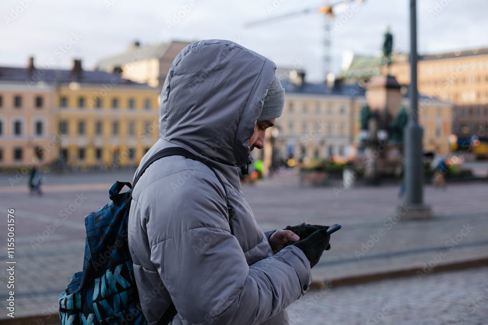 A handsome young adult man tourist using a mobile phone to get directions in a new city Helsinki, Finland, Europe A handsome young adult man tourist using a mobile phone to get directions in a new city Helsinki, Finland, Europe