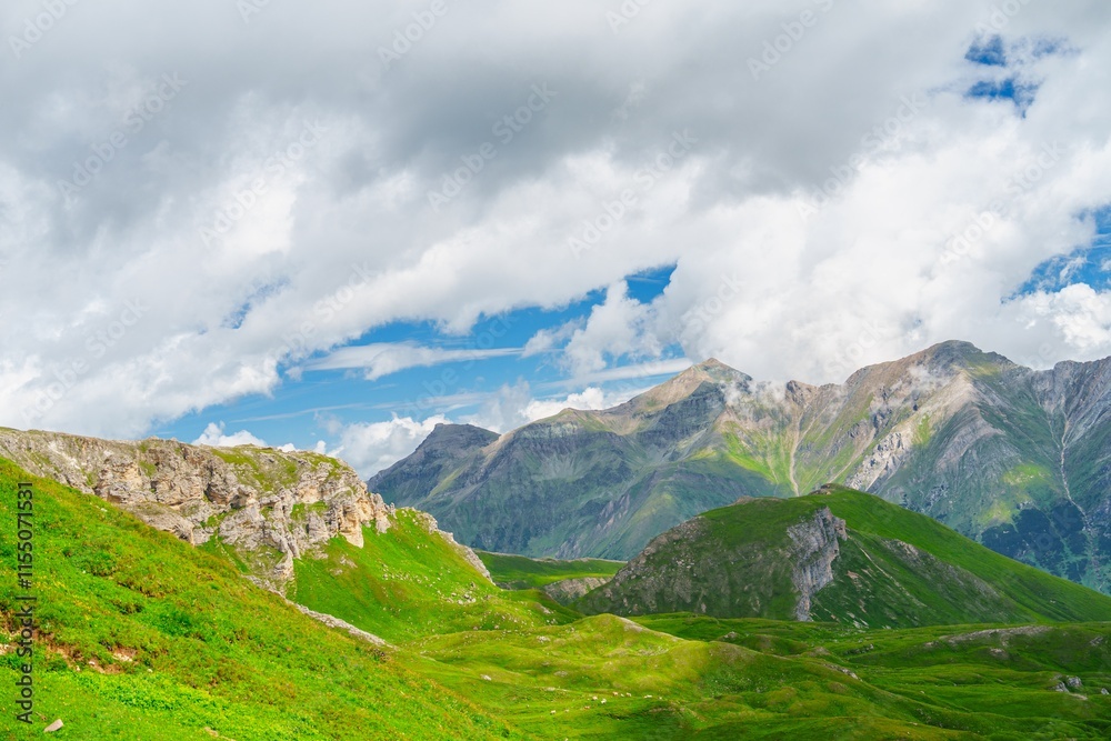 Obraz premium Explore the stunning landscapes of Kaprun, Austria. This photograph features lush green pastures, majestic mountains, and a serene cloudy sky, capturing the beauty of the Austrian Alps.